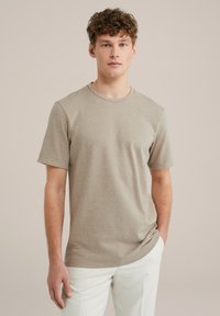Beige rövid ujjú póló strukturált anyagból, kerek nyakkivágással, laza szabással és minimalista dizájn részletekkel.