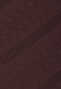 Tessuto a maglia bordeaux con un motivo testurizzato caratterizzato da forme geometriche in rilievo e dettagli con tagli orizzontali. Texture morbida, peso medio.