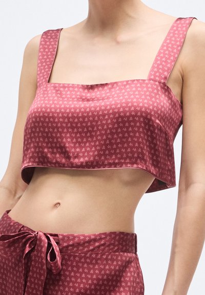 Lõigatud satiinist topp burgundiapunases, ruudukujulise kaelusega, laiad rihmad ja tagasihoidliku lillemustriga; sile tekstuur, veidi lahtine lõige.