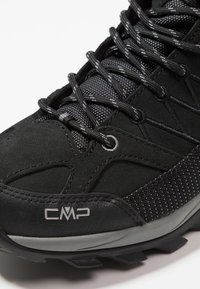 Schwarzer Wanderschuh aus einer Kombination aus Wildleder und Mesh-Materialien, mit strukturierten Akzenten und einer verstärkten Gummisohle mit einem Grip-Muster.