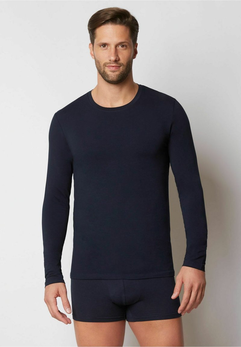 Marineblaue Langarmshirt aus einem glatten Material, kombiniert mit passgenauen Shorts, die über einen Rundhalsausschnitt und ein einfaches Design verfügen.
