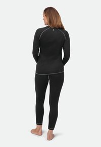 Black athletic long-sleeve top with contrasting gray stitching, paired with black fitted leggings. Soft material and slim fit.