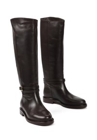 Brązowe skórzane buty jeździeckie z wysokimi cholewami, eleganckim wykończeniem, paskami w okolicy kostki i prostokątnymi niskimi obcasami. Gładka faktura z minimalnym przeszyciem.