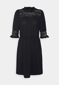 Robe noire courte aux genoux avec un empiècement en dentelle et des poignets à volants, des manches bouffantes, une taille cintrée et un col haut froncé ainsi que des extrémités de manches à volants.