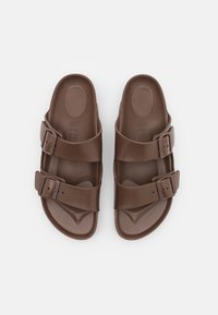 Brune sandaler med to justerbare spenner, glatt tekstur, formet foteng, og ergonomisk design for komfort og støtte.