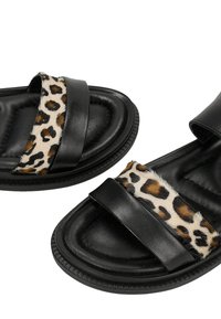 Zwarte platte sandalen met gevoerde zolen en twee banden, één effen zwart en één met een luipaardprint en een bontachtige textuur.