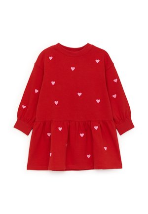 Vestido rojo de manga larga para niño pequeño con dobladillo fruncido en la falda y pequeños diseños de corazones rosas dispersos en la parte delantera y las mangas.