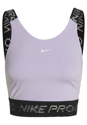 Brassière de sport violet clair avec des bretelles et une bande noires à motifs, arborant un petit logo Nike Swoosh blanc centré sur la poitrine.
