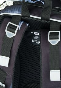 Rucksack mit einem schwarzen und grauen Mesh-Innenfutter und ergonomischem Design. Enthält verstellbare Träger und ein Branding-Tag mit der Bezeichnung "AIR ERGO ANATOMIC SYSTEM."