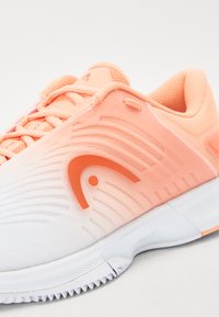 Leichte Sportschuh mit einem Verlaufdesign, das von Weiß zu hellpeach übergeht, mit strukturierten Mustern und orangenen Akzenten.