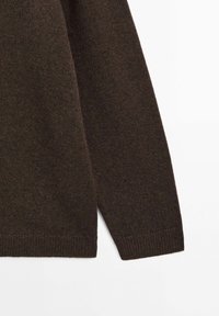 Brun stickad tröja med en strukturerad tygkvalitet, med rundad halsringning och ribbade ärmslut, som framhäver en sömlös design och en avslappnad passform.