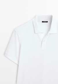 Weißes Poloshirt mit kurzen Ärmeln, Kragen, zwei Knöpfen und einem "Massimo Dutti"-Etikett im inneren Nackenbereich.