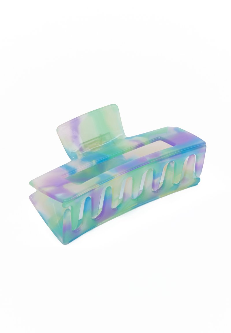 Flerfärgad plast hårklämma med en slät, glänsande yta, som har ett rektangulärt topp, böjd form och flera grepptänder längs botten.