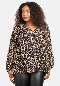Blusa con stampa leopardata in tessuto leggero, caratterizzata da scollatura a V e maniche lunghe con polsini arricciati, in tonalità di beige, nero e marrone.