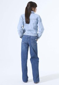 Light blue denim jacket with a fitted design, paired with wide-leg dark blue jeans. Both have classic stitching and back pockets.