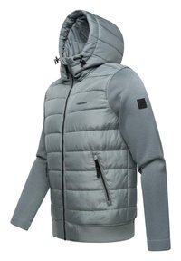 Padded ljusgrå hoodie-jacka med dragkedja fram, dragsko i huvan och ribbade ärmslut. Har strukturerade sidopaneler och två fickor med dragkedja.