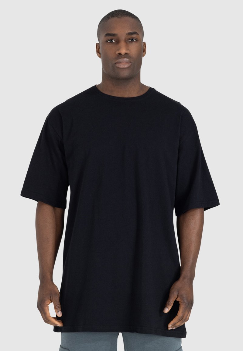 T-shirt in cotone nero con una vestibilità rilassata, maniche corte e scollo rotondo. Il tessuto appare liscio senza motivi o rifiniture visibili.