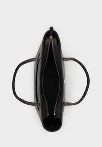 Mala tote preta com um design estruturado, exterior liso, duas alças de ombro e uma abertura superior com fecho éclair que revela um interior forrado.