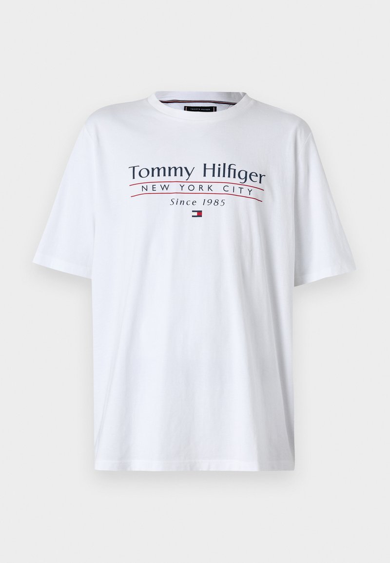 Balta medvilninė marškinėliai su trumpomis rankovėmis, kuriuose yra tamsiai mėlynos ir raudonos spalvos užrašas "Tommy Hilfiger New York City Since 1985" bei mažas logotipo akcentas.