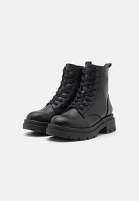 Black leather combat boots with a high ankle, round toe, lace-up design, thick rubber sole, and rear pull tab.