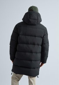 Čierna oblá pánska bunda s kapucňou, s horizontálnym švom a dlhším strihom. Obsahuje nastaviteľné šnúrky na leme.