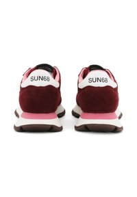 Une paire de baskets bordeaux et rose avec des talons blancs, un intérieur noir, et la marque "SUN68" au dos de chaque chaussure.