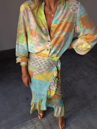 Flerfarget silke bluse med et bladgrønt og havmønster, satt sammen med et volangskjørt med et kartdesign i pastellfarger.