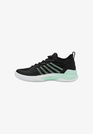 Sapatos atléticos pretos com um upper texturizado, detalhes em verde menta e uma sola de borracha branca com um padrão de ranhuras em zig-zag.