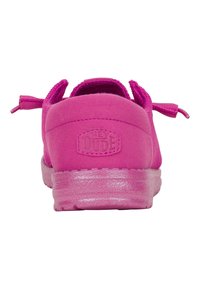 Zapato de slip-on de color rosa brillante con una parte superior texturizada, tela suave y una suela de goma semitransparente. Presenta un logo en la parte trasera.