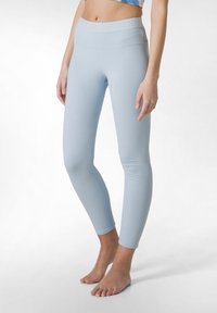 Leggings azzurri chiari realizzati in tessuto morbido, con un alto punto vita e un branding sottile, gambe aderenti e lunghezza alla caviglia.