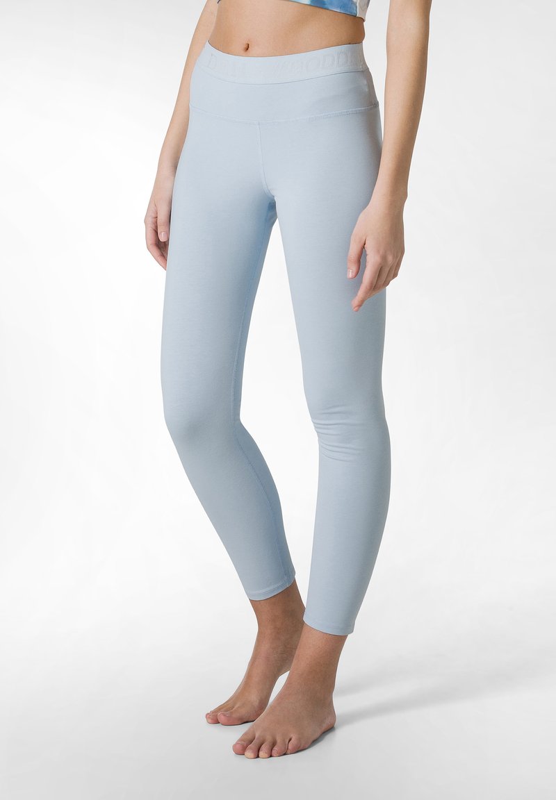 Leggings azzurri chiari realizzati in tessuto morbido, con un alto punto vita e un branding sottile, gambe aderenti e lunghezza alla caviglia.