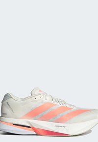 Άσπρο και ανοιχτό ρόζ παπούτσι τρεξίματος Adidas με επάνω μέρος από δίχτυ, τρεις ροζ ρίγες και "Lightstrike Pro" στη μεσαία σόλα.