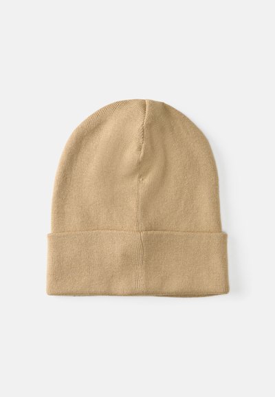 Gorro de tricot beje com dobra na bainha, apresentando uma textura suave e forma arredondada, adequado para o clima mais fresco.