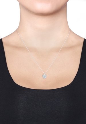 Silberne Halskette mit einem herzförmigen Anhänger, der eine strukturierte, funkelnde Oberfläche hat, an einer dünnen Kette hängt. Einfaches und elegantes Design.