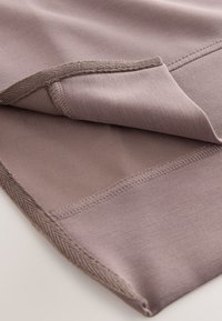 Tessuto morbido color malva con una texture liscia, caratterizzato da un bordo arrotolato e cuciture di colore più scuro a contrasto. Leggero lucido con un drappeggio flessibile.