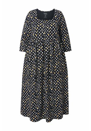 Černé šaty s dlouhými rukávy a čtvercovým výstřihem, se vzorem bílých a žlutých teček. Rozšířená, splývavá sukně, ležérní design.
