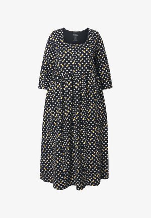 Vestido negro con mangas largas y escote cuadrado, que presenta un patrón de puntos blancos y amarillos. Falda acampanada y fluida, diseño casual.