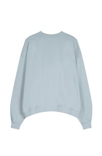 Svetlomodrá mikina s okrúhlym výstrihom, spadnutými ramenami a mierne skráteným lemom. Vyrobená z mäkkej textílie s hladkou štruktúrou.