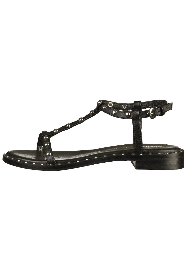 Černé kožené sandály s T-strap designem, hřebíkované akcenty podél podrážky, plochým podpatkem a nastavitelným kotníkovým přezkovým zapínáním. Hladký povrch.