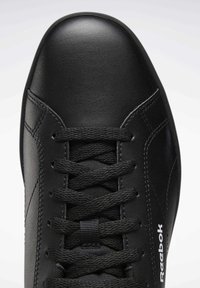 Basket en cuir noir Reebok avec lacets noirs, vue en gros plan centrée sur la zone des orteils et des lacets.