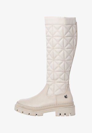 Botte crème montante jusqu'au genou avec tige en tissu matelassé, semelle épaisse à stries, et petit emblème floral en métal sur la zone du talon.