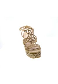 Sandal con tacco alto beige con design intricato della fascia metallica, piattaforma in juta intrecciata e superficie in morbido suede sulla soletta.