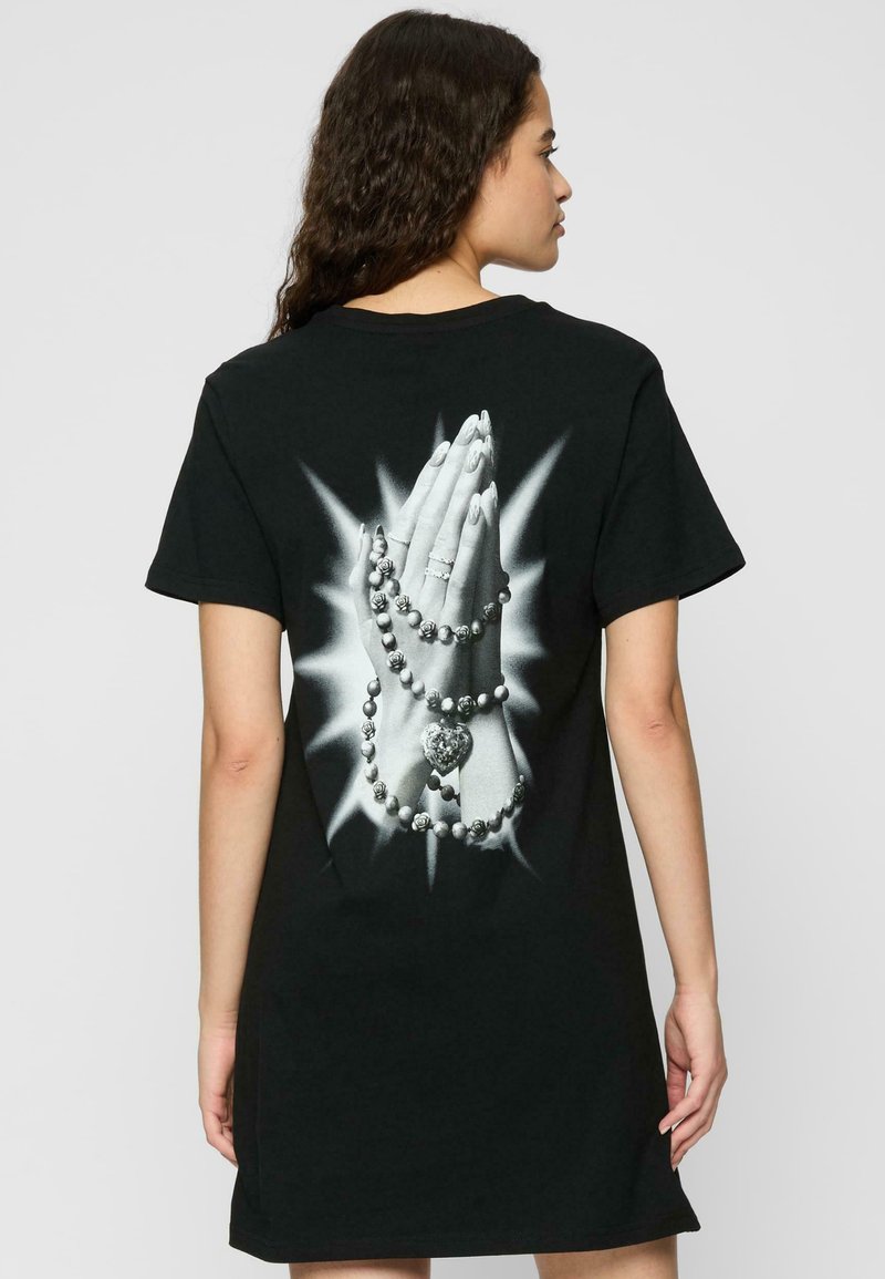 Robe t-shirt noire avec un imprimé graphique de mains jointes ornées de perles et d'un cœur dans le dos, à manches courtes et coupe décontractée.