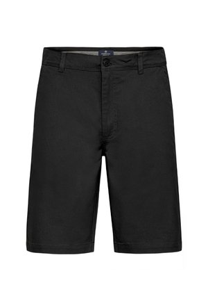 Lyhyet mustat housut, jotka on valmistettu sileäpintaisesta kankaasta. Niissä on edessä nappikiinnitys, vyölenkit ja suora leikkaus, jossa on viistetyt reunat.