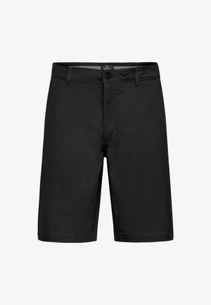 Juodi šortai, pagaminti iš audinio su lygiu paviršiumi. Savybės: priekyje yra mygtukų užsegimas, dirželio kilpos ir tiesus kirpimas su apdirbtu kraštu.