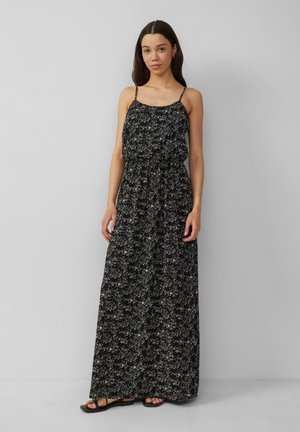Maxi-jurk van zwarte stof met een witte bloemenprint, voorzien van dunne bandjes en een elastische taille voor een ontspannen pasvorm. Platte zwarte sandalen.
