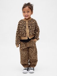 Kardigan z leopardjim vzorom in ujemajoče hlače v rjavi in črni barvi. Pulover ima okroglo izrezano in gumbno zapiranje; hlače imajo elastični pas.