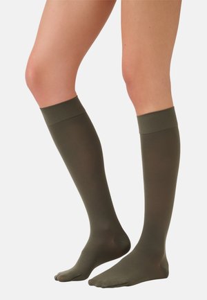Kniehoogte sokken in olijfgroen, gemaakt van een soepele, rekbare stof met een geribde boord, die een effen kleur en eenvoudig ontwerp tonen.