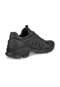 Chaussure de sport noire avec une tige texturée, des détails en mesh, un design élégant et une semelle sculptée pour une meilleure traction.