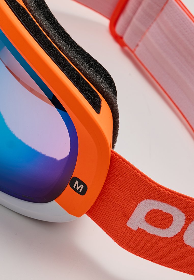 Pomarańczowe gogle narciarskie z niebieskimi, lustrzanymi soczewkami, czarną pianką wyściółki oraz regulowanym pomarańczowym paskiem oznaczonym białym, częściowym logo i etykietą rozmiaru "M".